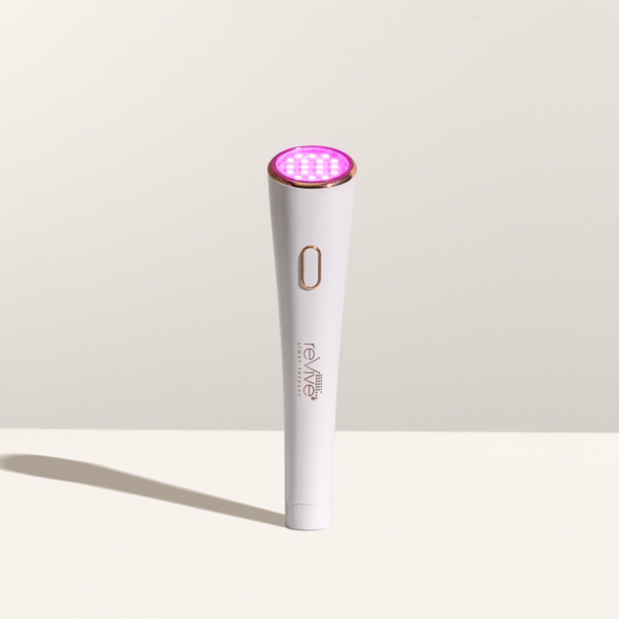 Handheld reVive Light Therapy wand with its red LED light switched on